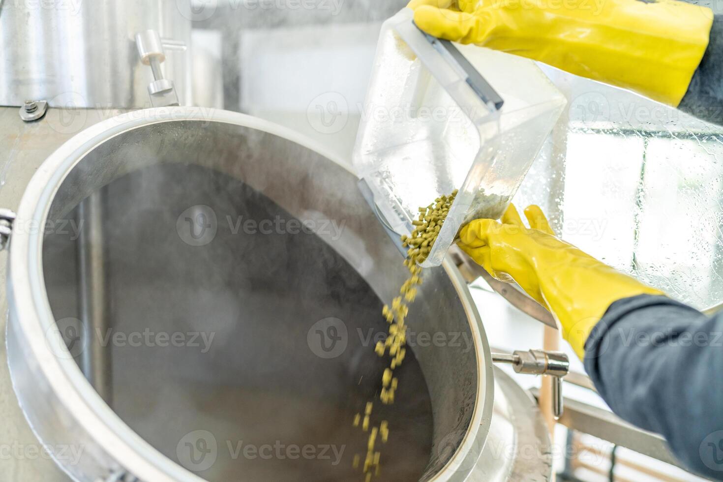 dried granulated hops in the brewery when brewing beer. added to a stainless steel tank when brewing beer photo