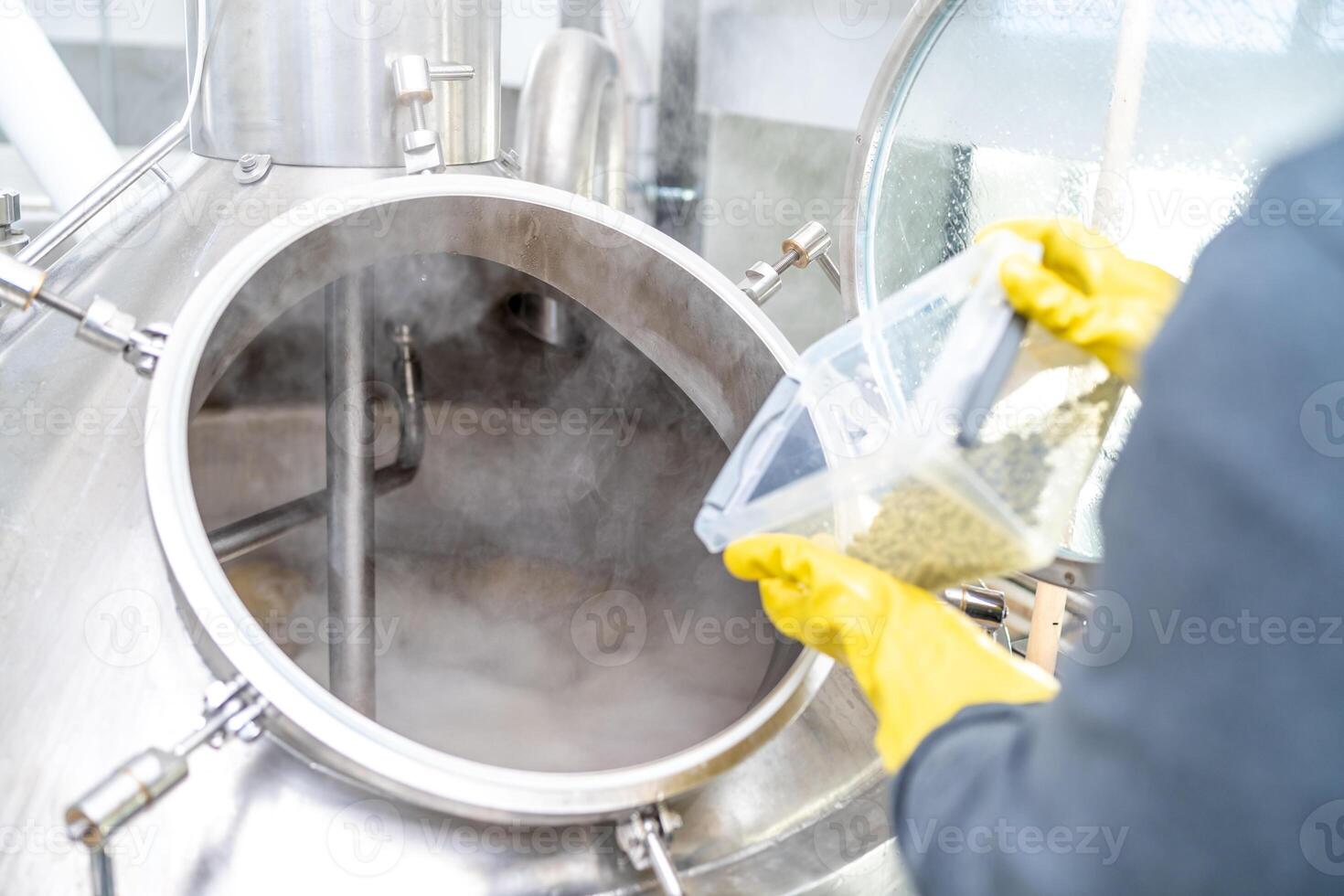 dried granulated hops in the brewery when brewing beer. added to a stainless steel tank when brewing beer photo