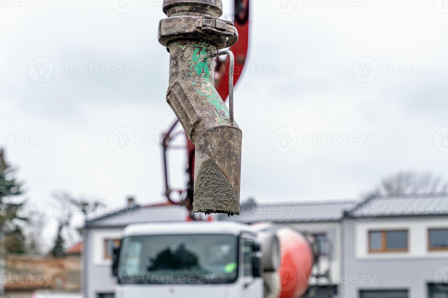 pouring concrete from a mixer truck with a hose into the foundation of the house photo