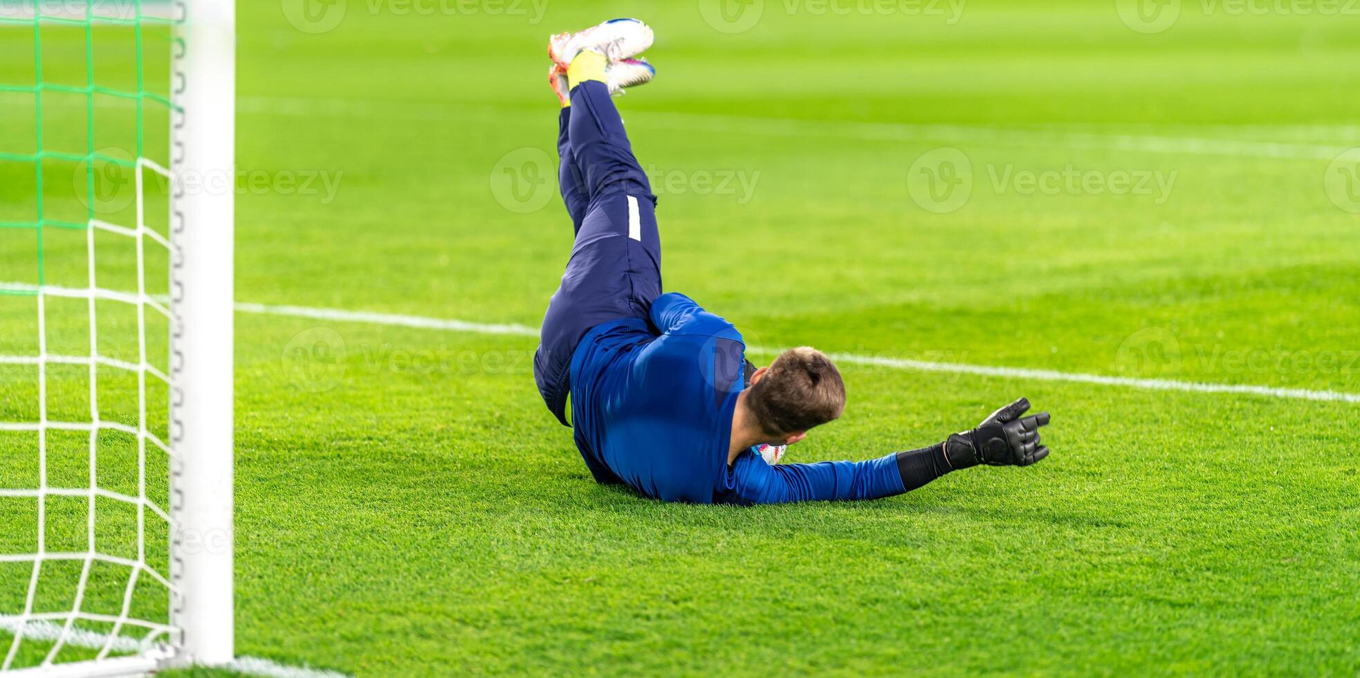 goalkeeper catches the ball in the goal in a soccer match photo