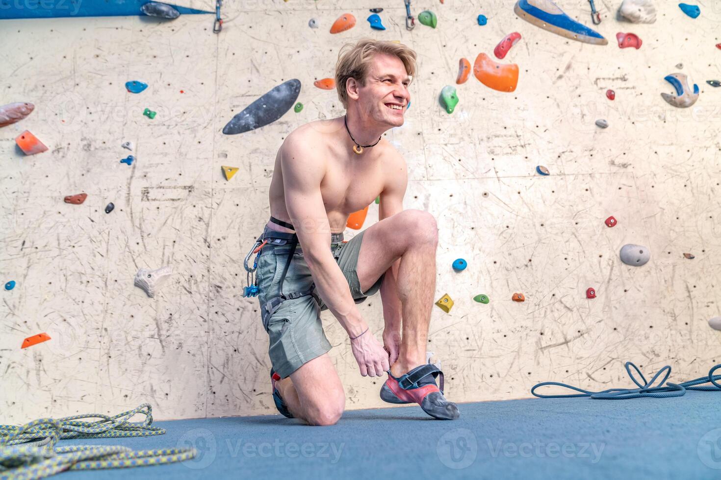 putting on climbing shoes next to the climbing wall photo