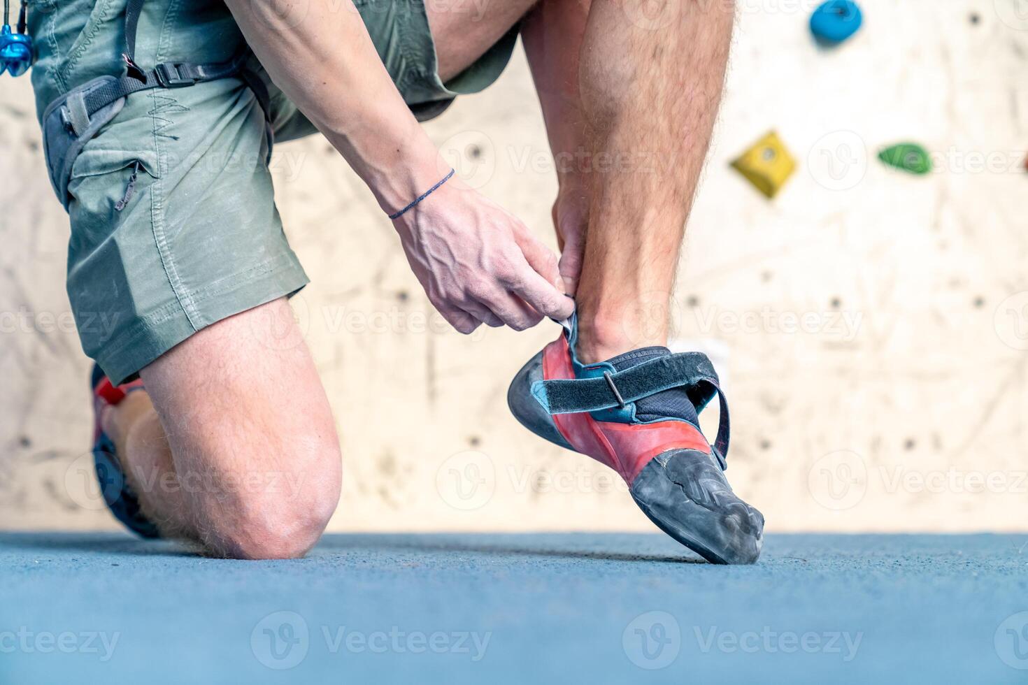 putting on climbing shoes next to the climbing wall photo