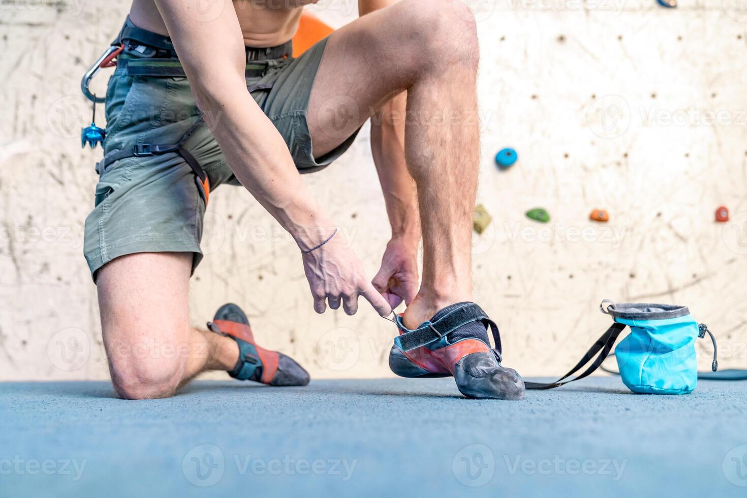 putting on climbing shoes next to the climbing wall photo
