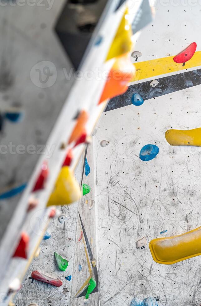 artificial climbing wall with grips and carabiners in the interior photo