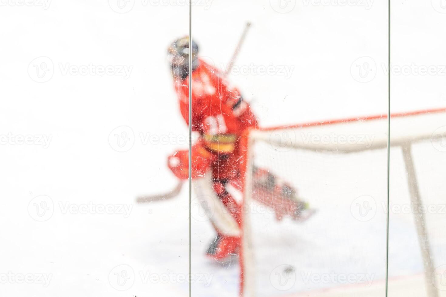 blurred view through protective safety glass. hockey goalie on the ice of the winter stadium, background photo