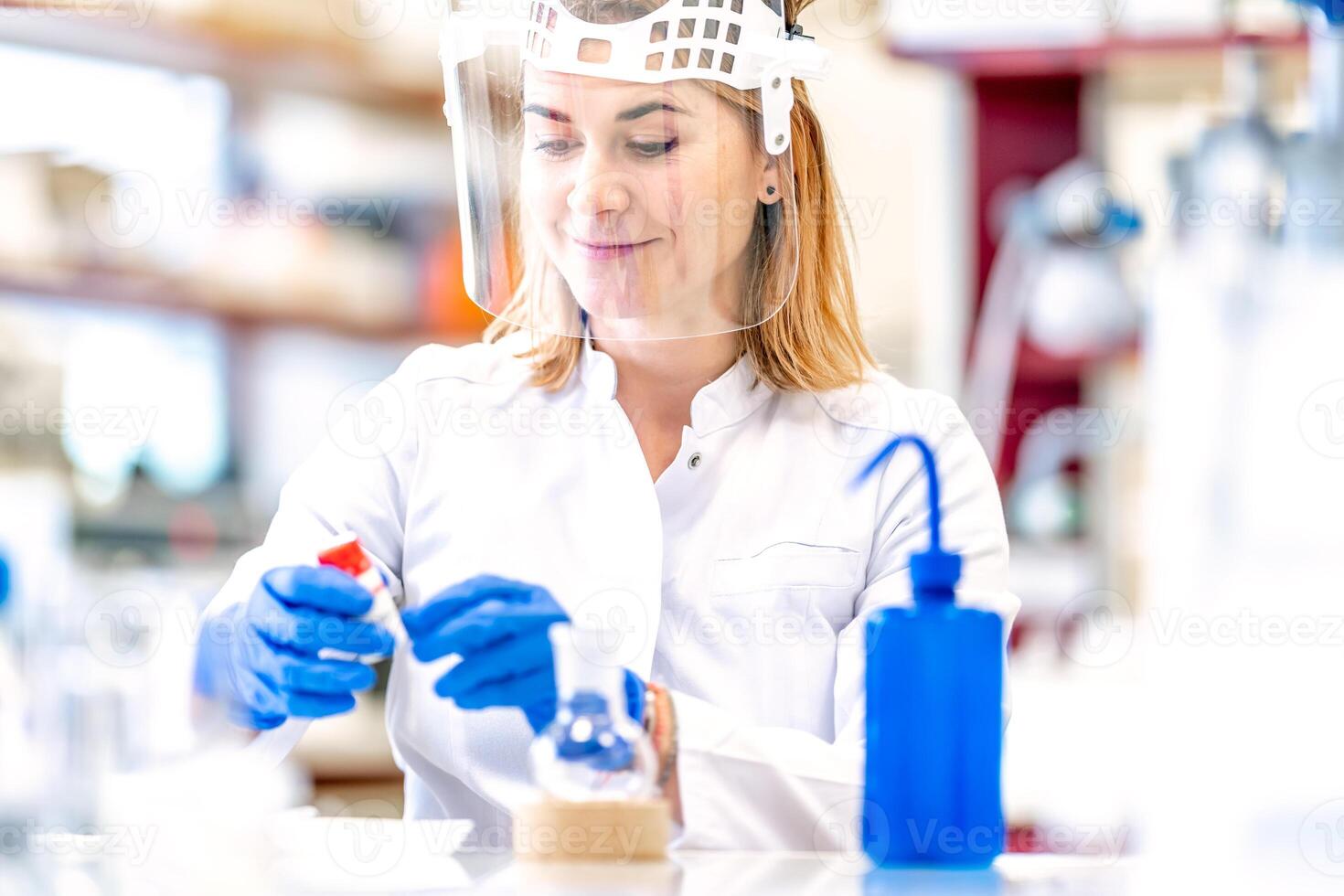research of dangerous chemical substances in a biochemical laboratory. female scientist uses protective equipment photo