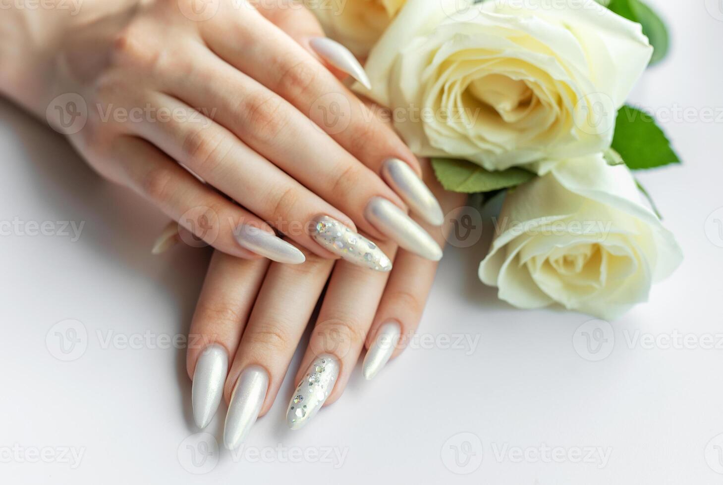 Female Hands with beautiful pearl manicure and white roses photo