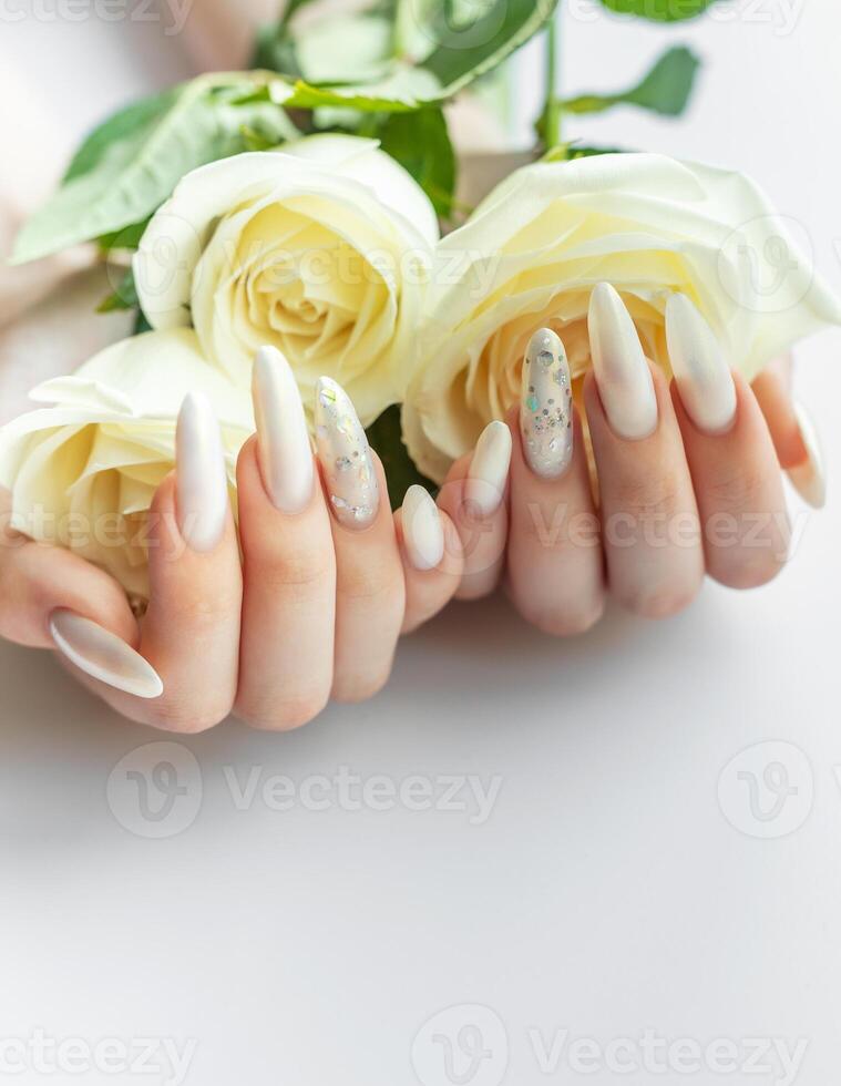 Female Hands with beautiful pearl manicure and white roses photo