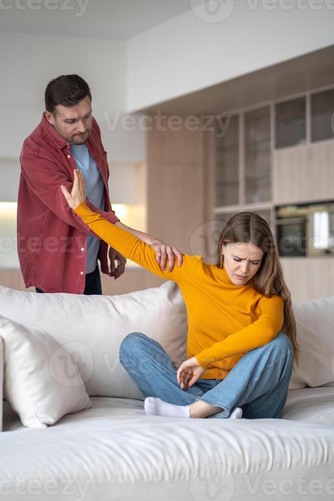 Frustrated offended woman ignoring angry annoyed man grabbing hand, relationship crisis at home. photo