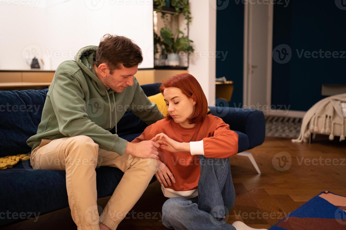 Loving supportive husband holding hand of sad wife photo