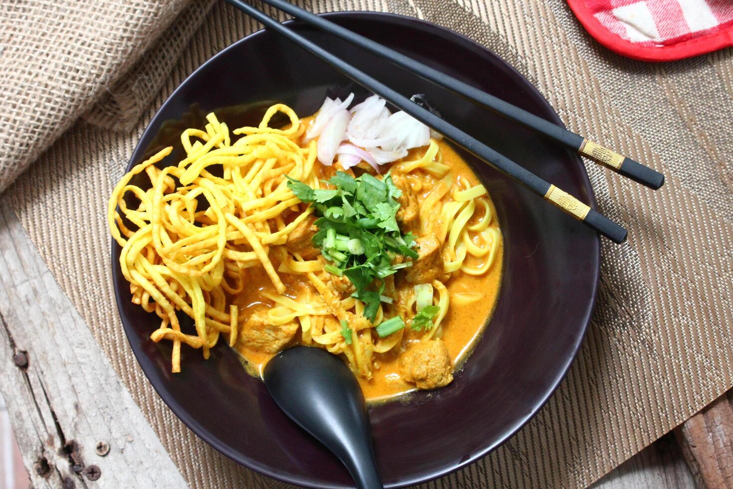 Aromatic Khao Soi with egg noodles in a rich coconut curry broth. photo