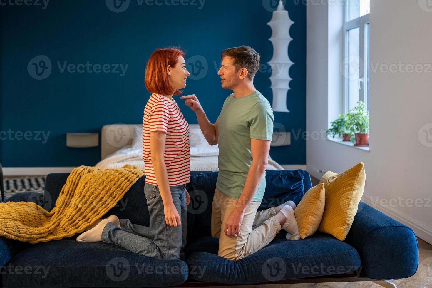 Negative emotions of couples concept. Husband and wife arguing and shouting, home standing on couch photo