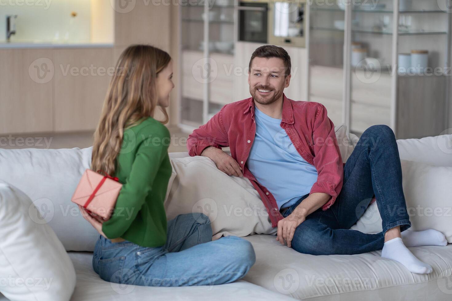 Smiling wife going to give husband pleasant surprise gift for birthday, Christmas, anniversary. photo