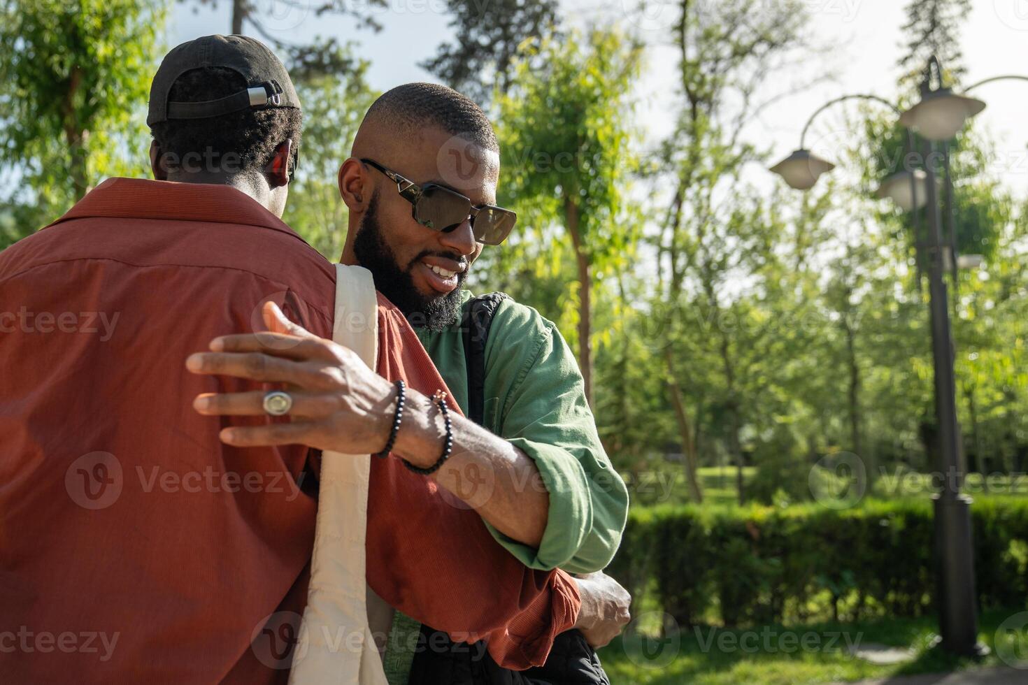 Happy African American guys hugging on street, greeting, meeting, embracing, saying goodbye, hello. photo