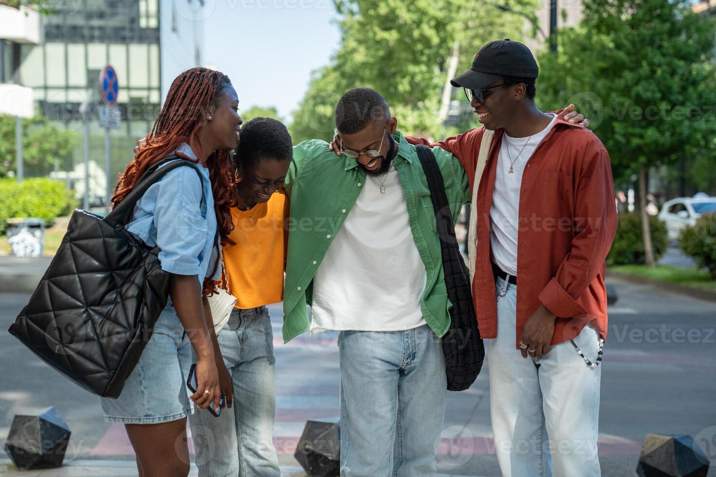 Happy joyful group of black stylish friends laughs, smiling, have fun while urban walking together. photo