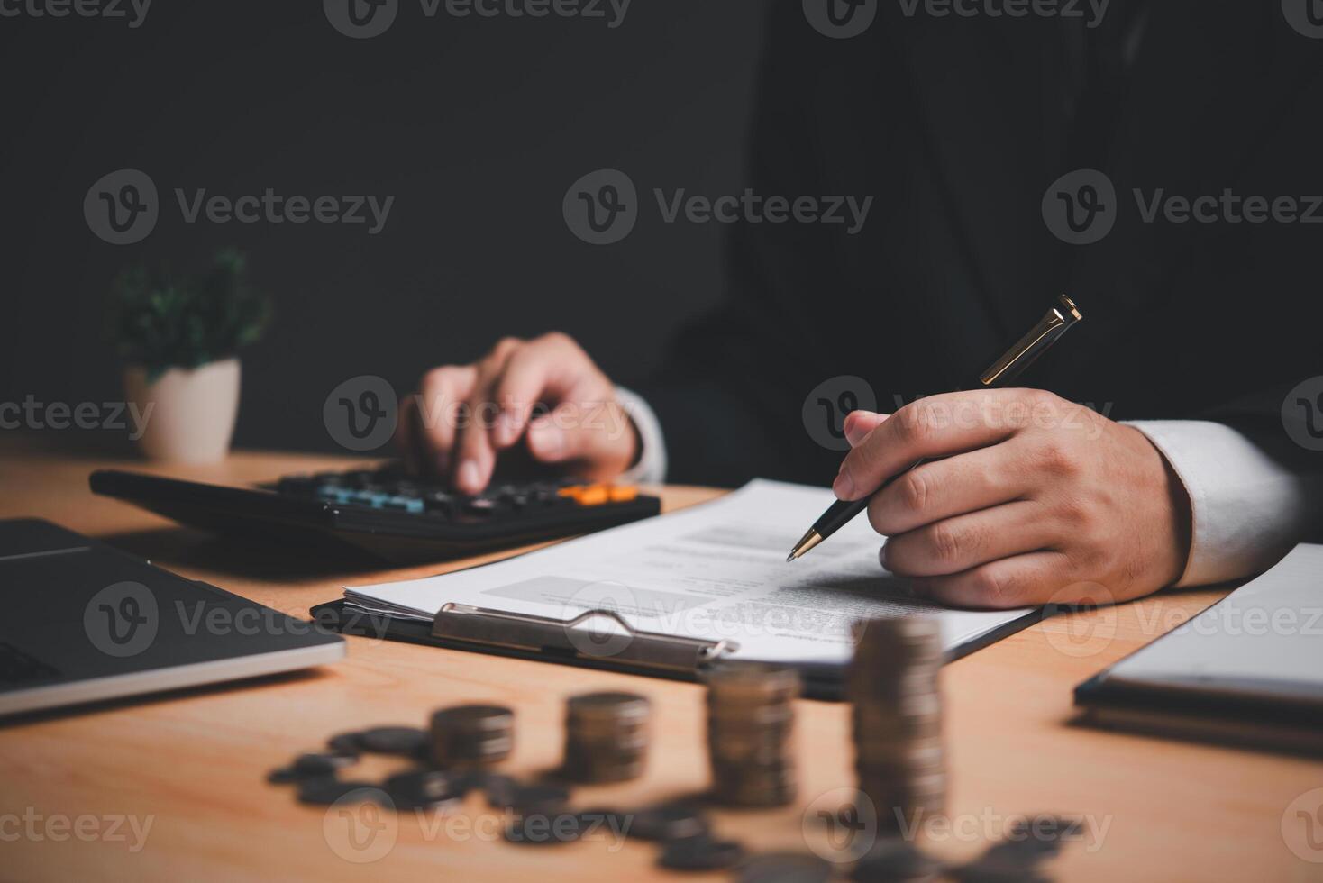 Person calculating financial data with pen and calculator. Money management, business accounting. Professional financial analysis. Corporate budgeting and planning. photo