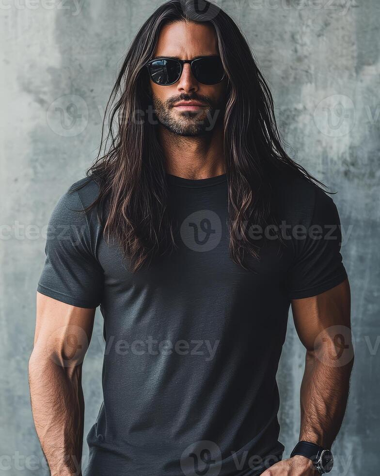 A handsome model with long hair poses in a minimalist environment while wearing a t-shirt photo