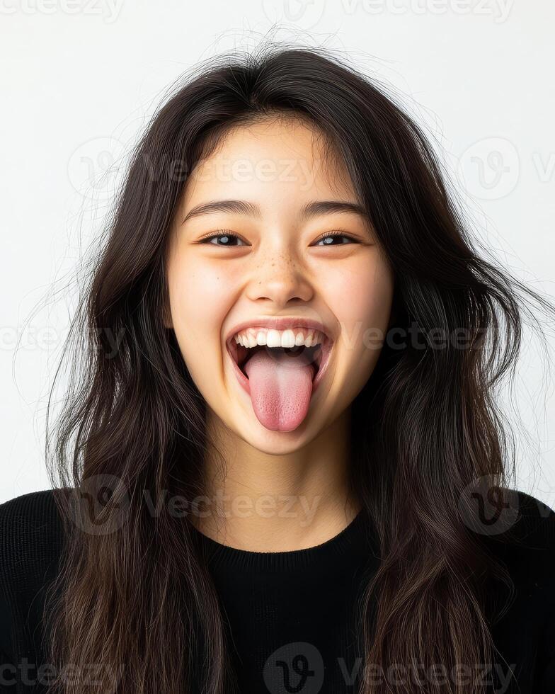 A cheerful girl expresses joy with a playful gesture of sticking out her tongue photo