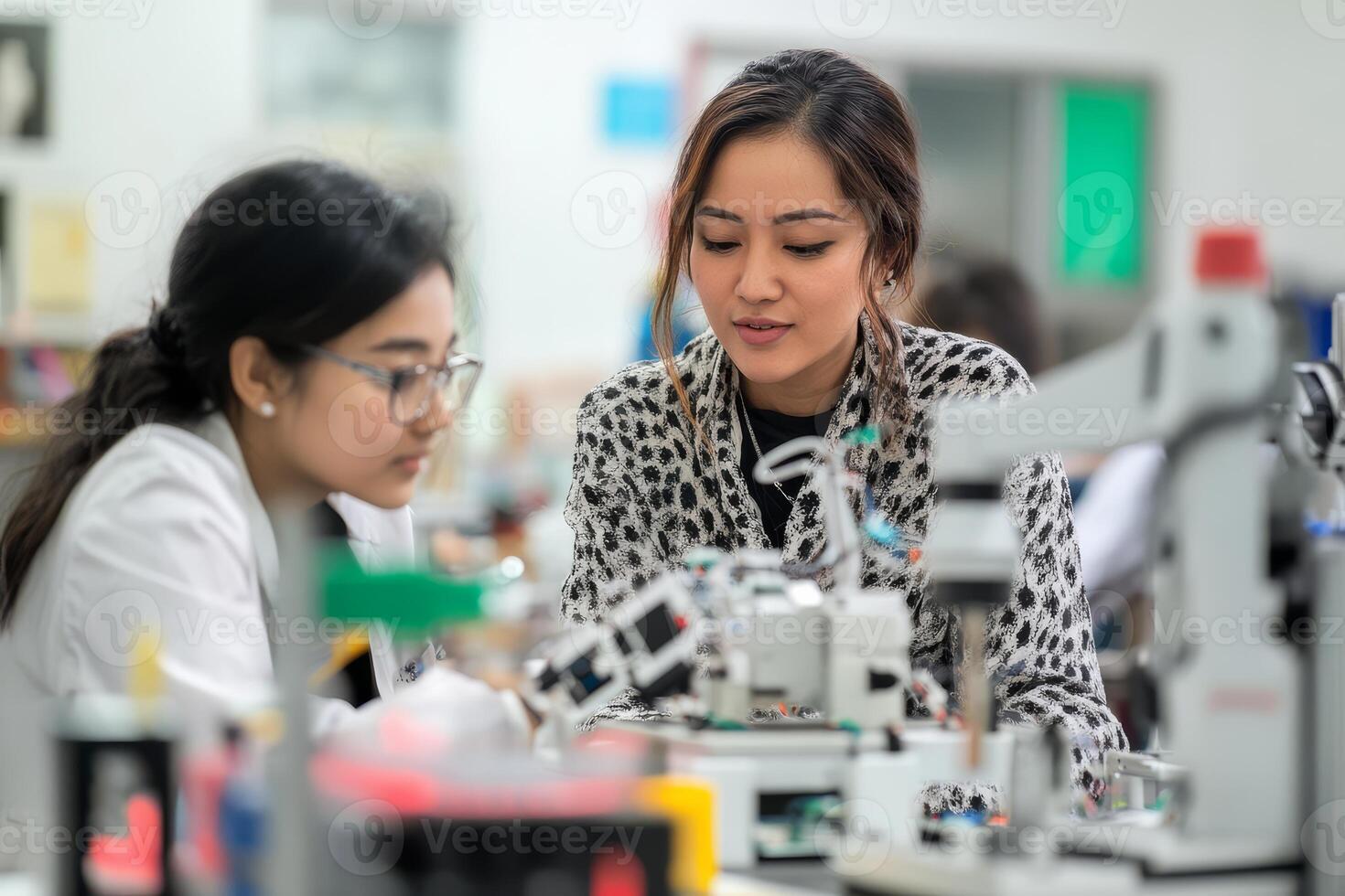 Two scientists work closely together on an experiment at a lab bench photo
