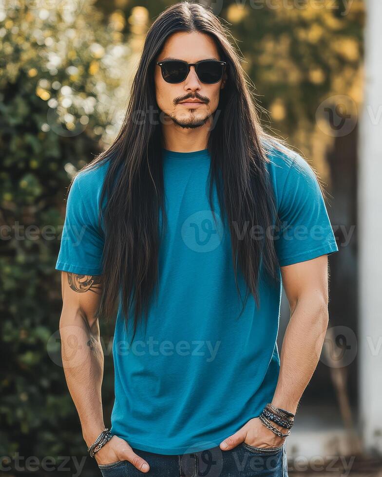 A handsome model showcases a blank blue t-shirt in a sunlit garden photo
