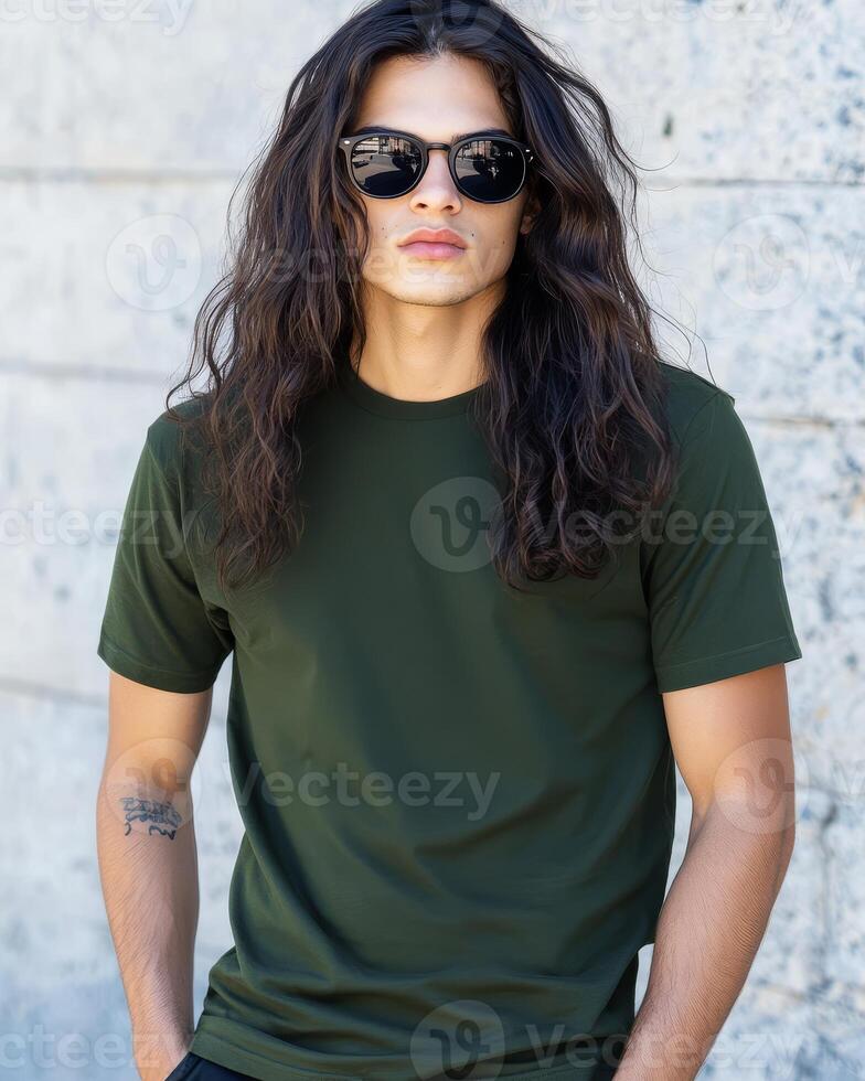 Model with long hair flaunts a blank t-shirt against a textured wall backdrop photo