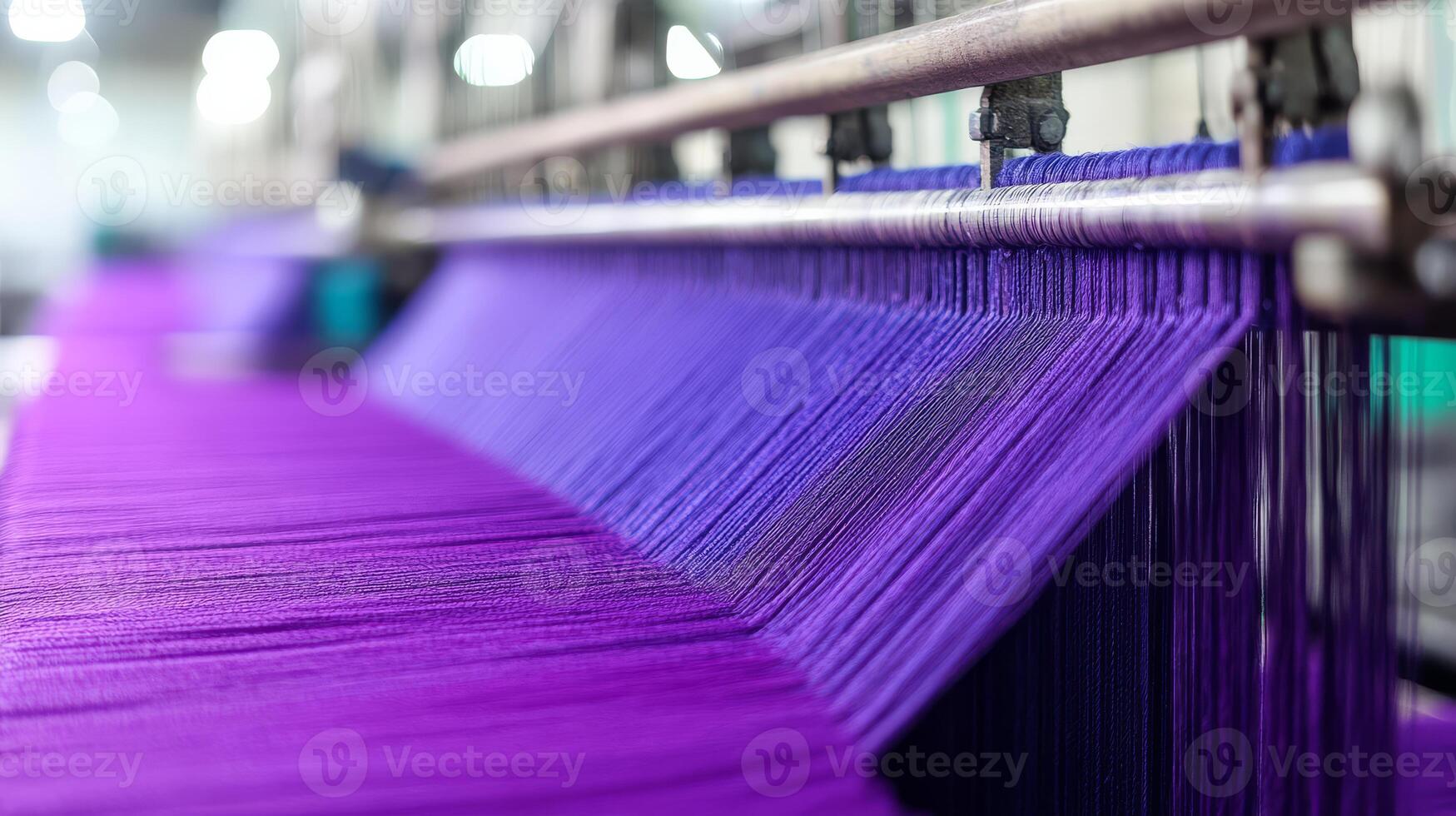 Threads of deep purple flow gracefully through a textile creation process photo