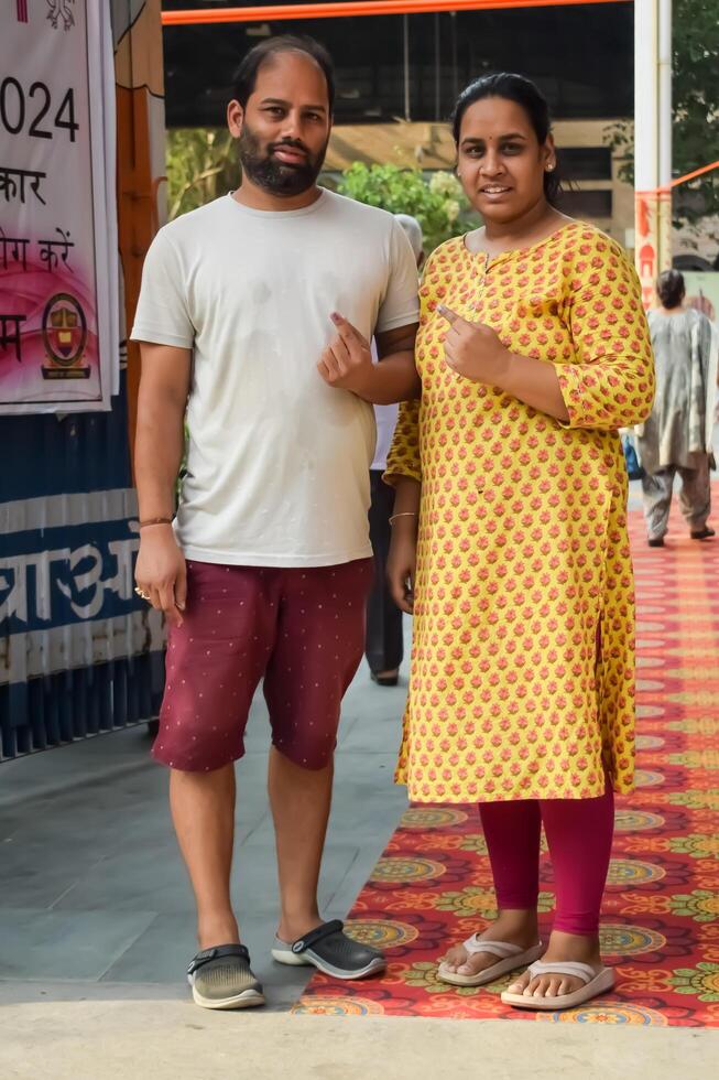 New Delhi, India - May 25 2024 - Unidentified people showing their ink-marked fingers after casting votes in front of polling booth of east Delhi area for general Lok Sabha Elections 2024 photo