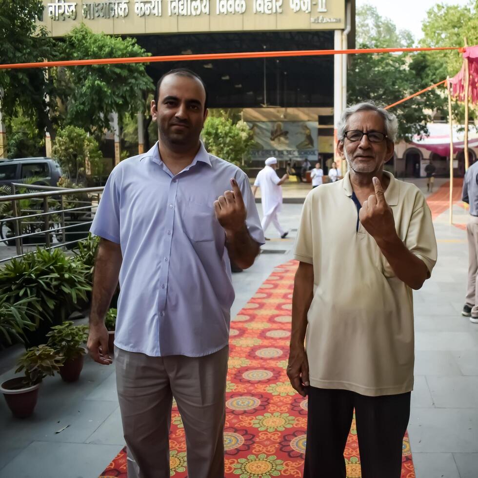 New Delhi, India - May 25 2024 - Unidentified people showing their ink-marked fingers after casting votes in front of polling booth of east Delhi area for general Lok Sabha Elections 2024 photo