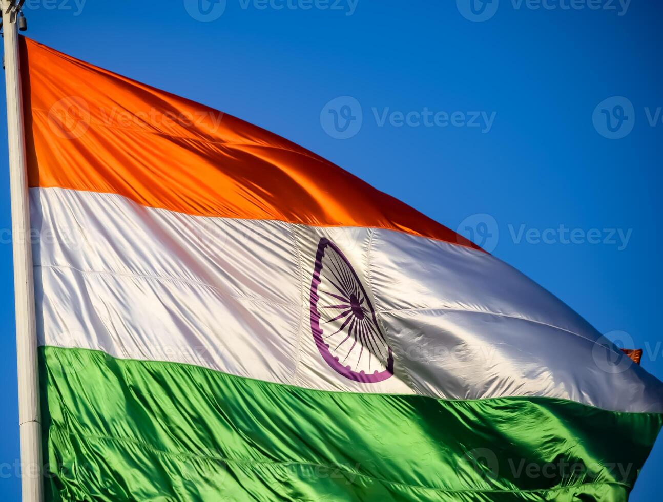 India flag flying high at Connaught Place with pride in blue sky, India flag fluttering, Indian Flag on Independence Day and Republic Day of India, tilt up shot, Waving Indian flag, Har Ghar Tiranga photo