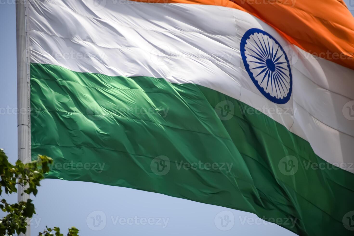 India flag flying high at Connaught Place with pride in blue sky, India flag fluttering, Indian Flag on Independence Day and Republic Day of India, tilt up shot, Waving Indian flag, Har Ghar Tiranga photo
