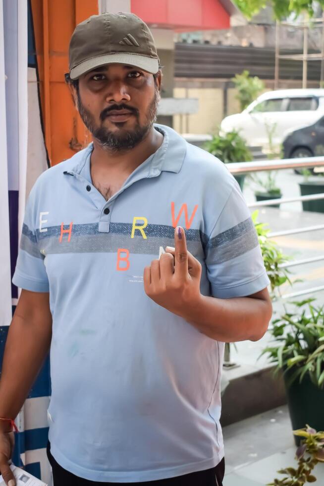 New Delhi, India - May 25 2024 - Unidentified people showing their ink-marked fingers after casting votes in front of polling booth of east Delhi area for general Lok Sabha Elections 2024 photo