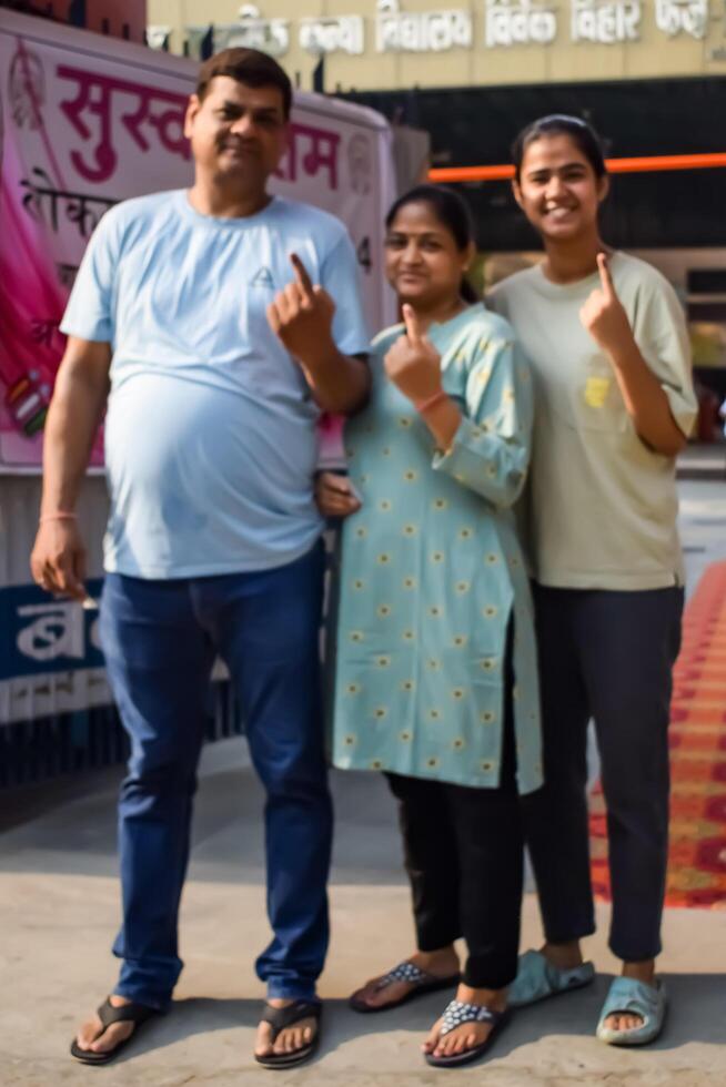 New Delhi, India - May 25 2024 - Unidentified people showing their ink-marked fingers after casting votes in front of polling booth of east Delhi area for general Lok Sabha Elections 2024 photo