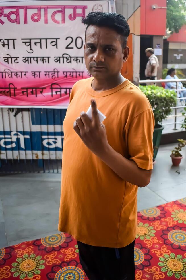 New Delhi, India - May 25 2024 - Unidentified people showing their ink-marked fingers after casting votes in front of polling booth of east Delhi area for general Lok Sabha Elections 2024 photo