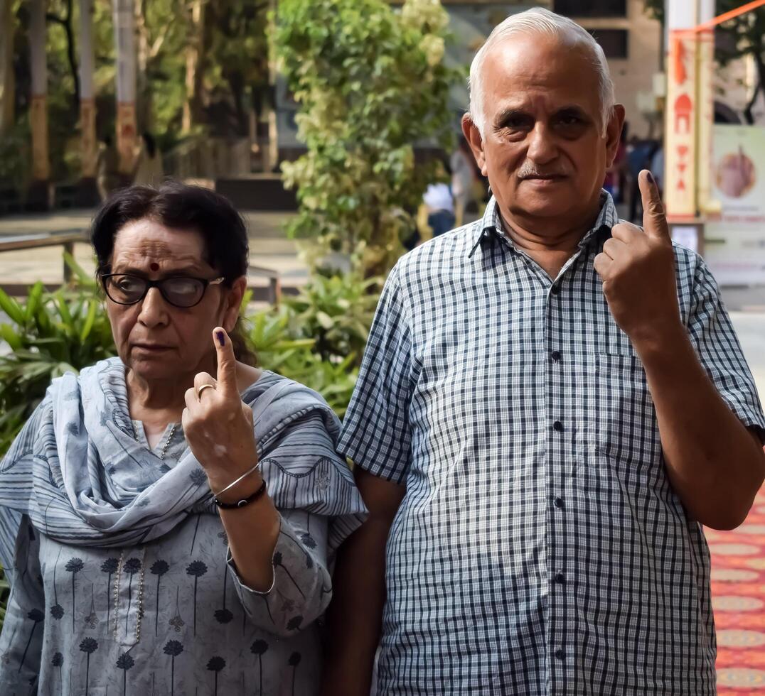 New Delhi, India - May 25 2024 - Unidentified people showing their ink-marked fingers after casting votes in front of polling booth of east Delhi area for general Lok Sabha Elections 2024 photo