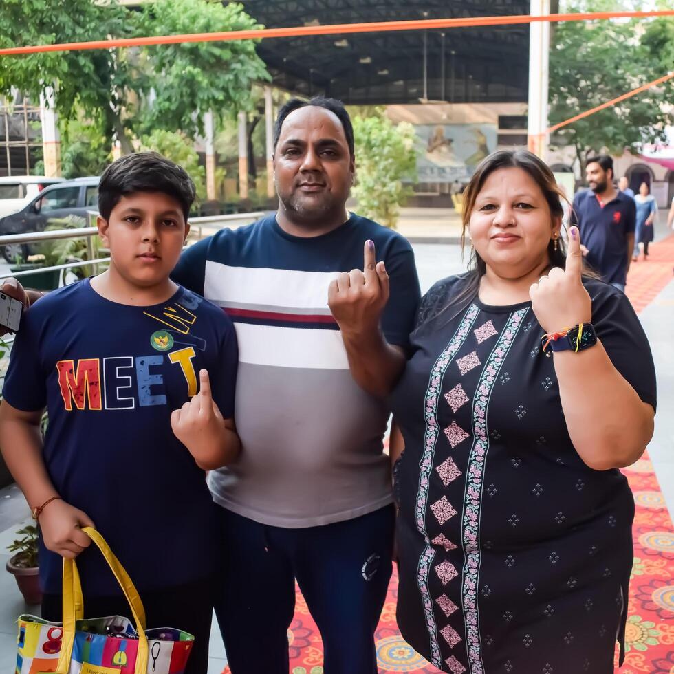 New Delhi, India - May 25 2024 - Unidentified people showing their ink-marked fingers after casting votes in front of polling booth of east Delhi area for general Lok Sabha Elections 2024 photo