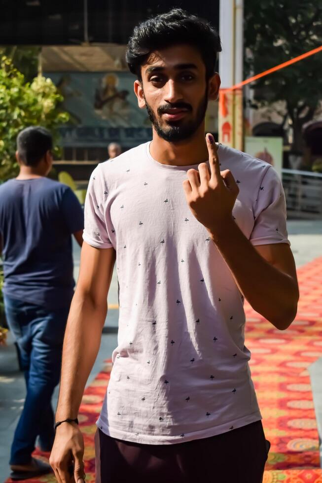 New Delhi, India - May 25 2024 - Unidentified people showing their ink-marked fingers after casting votes in front of polling booth of east Delhi area for general Lok Sabha Elections 2024 photo