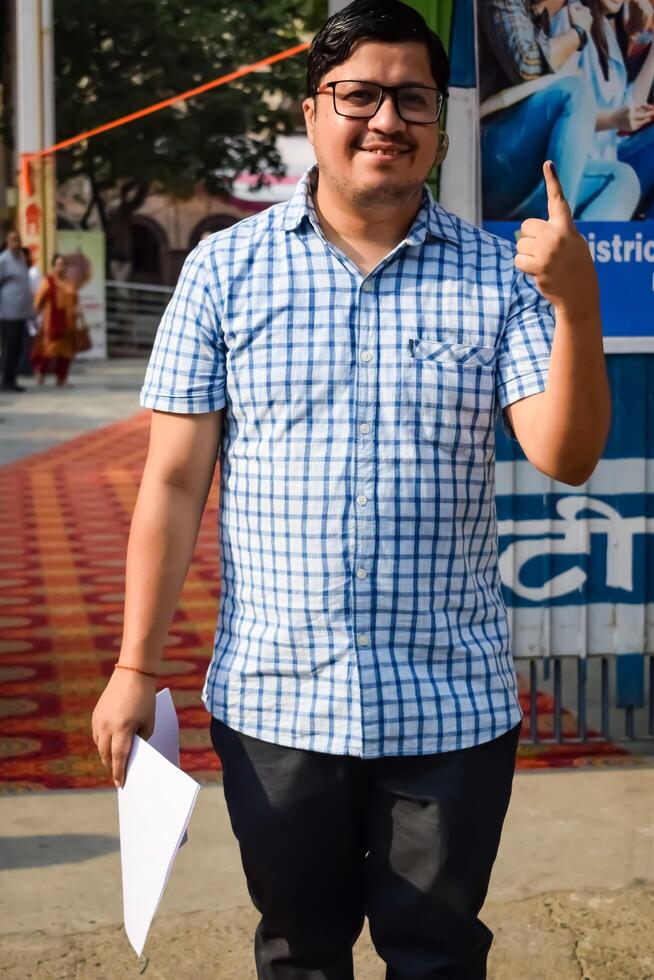 New Delhi, India - May 25 2024 - Unidentified people showing their ink-marked fingers after casting votes in front of polling booth of east Delhi area for general Lok Sabha Elections 2024 photo