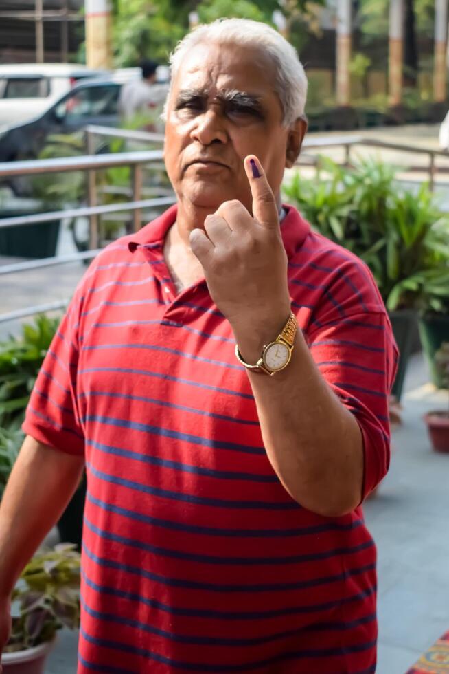 New Delhi, India - May 25 2024 - Unidentified people showing their ink-marked fingers after casting votes in front of polling booth of east Delhi area for general Lok Sabha Elections 2024 photo