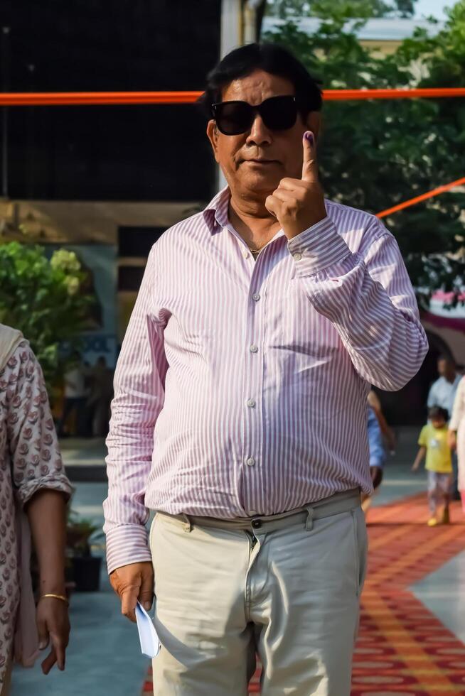 New Delhi, India - May 25 2024 - Unidentified people showing their ink-marked fingers after casting votes in front of polling booth of east Delhi area for general Lok Sabha Elections 2024 photo