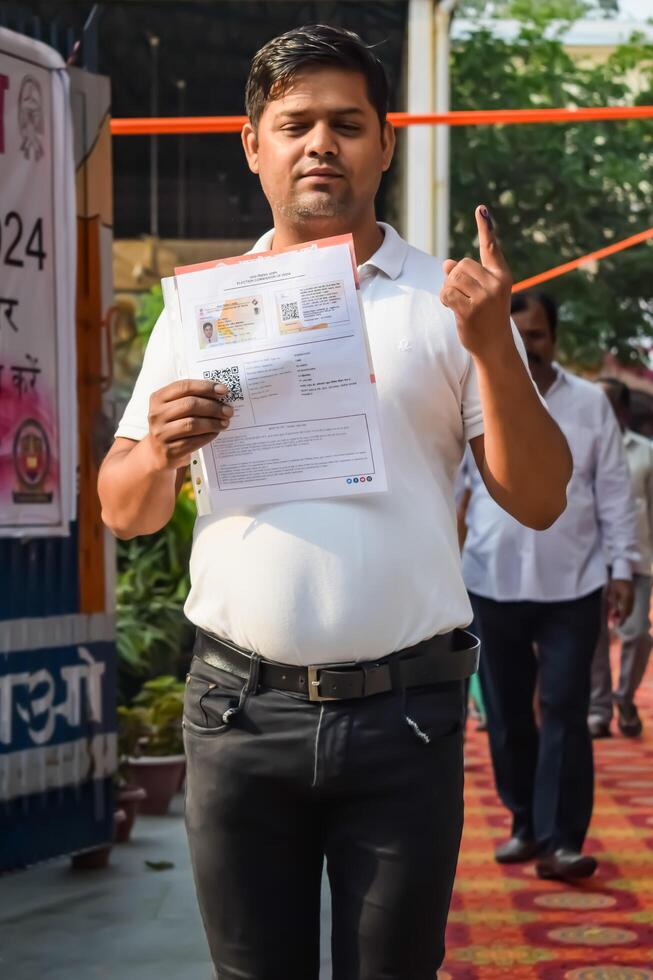 New Delhi, India - May 25 2024 - Unidentified people showing their ink-marked fingers after casting votes in front of polling booth of east Delhi area for general Lok Sabha Elections 2024 photo