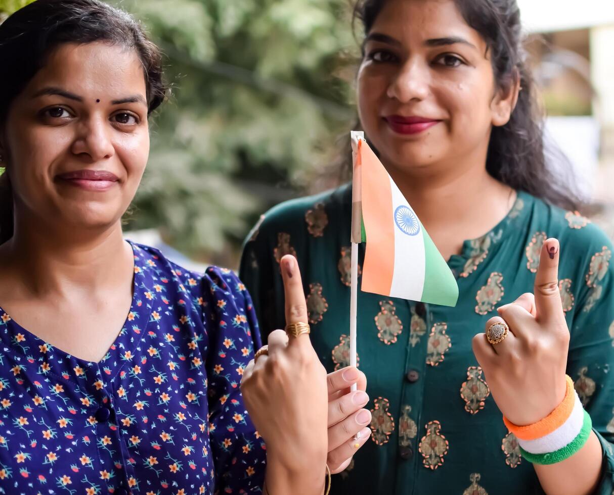Two Smart young lady showing her ink-marked fingers after casting votes in front of polling booth of east Delhi area for general Lok Sabha Elections 2024 photo