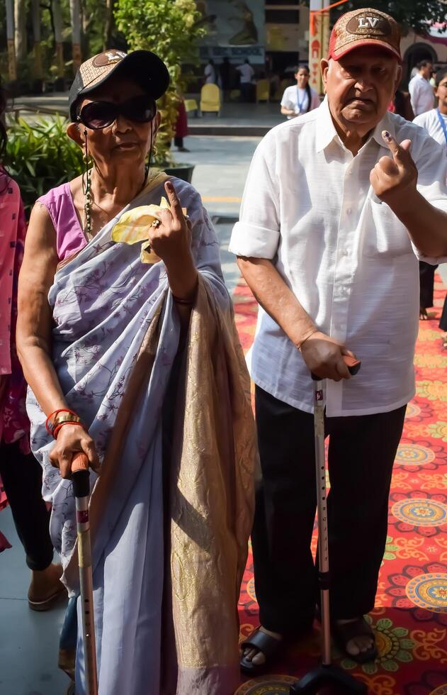 New Delhi, India - May 25 2024 - Unidentified people showing their ink-marked fingers after casting votes in front of polling booth of east Delhi area for general Lok Sabha Elections 2024 photo