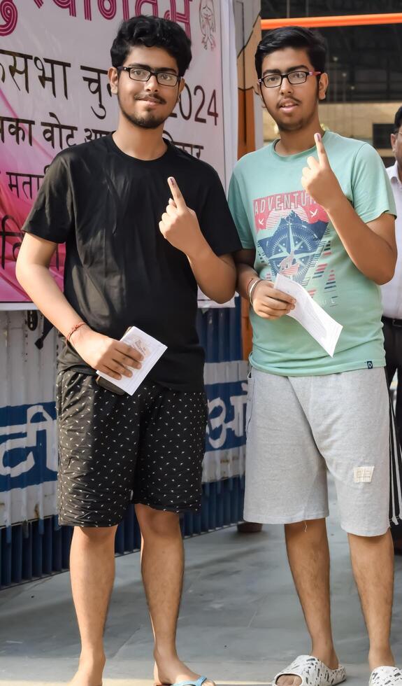 New Delhi, India - May 25 2024 - Unidentified people showing their ink-marked fingers after casting votes in front of polling booth of east Delhi area for general Lok Sabha Elections 2024 photo