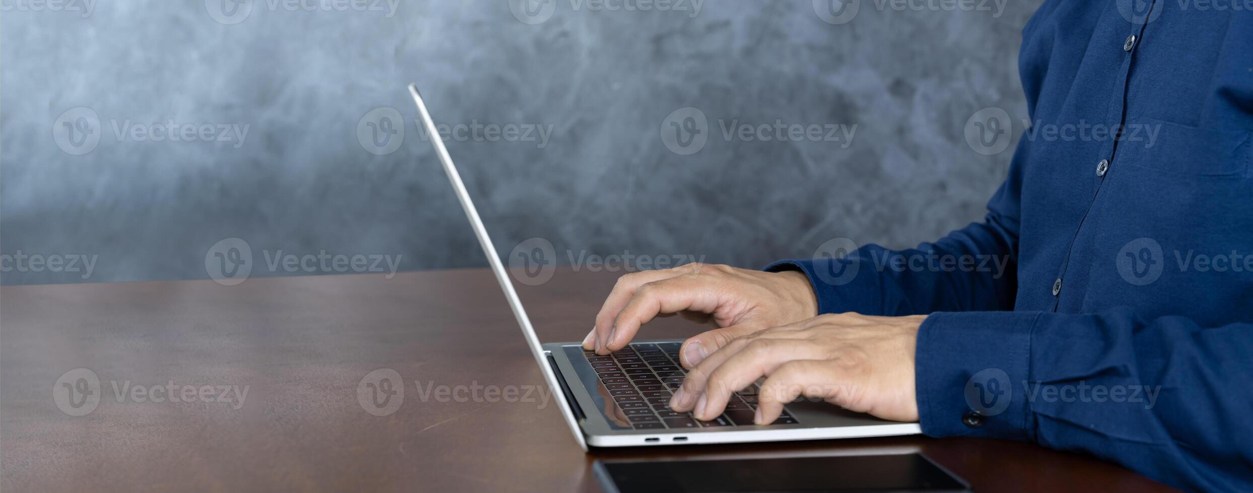 Close up businessman typing on a laptop computer at home. A man browsing the internet at home. photo