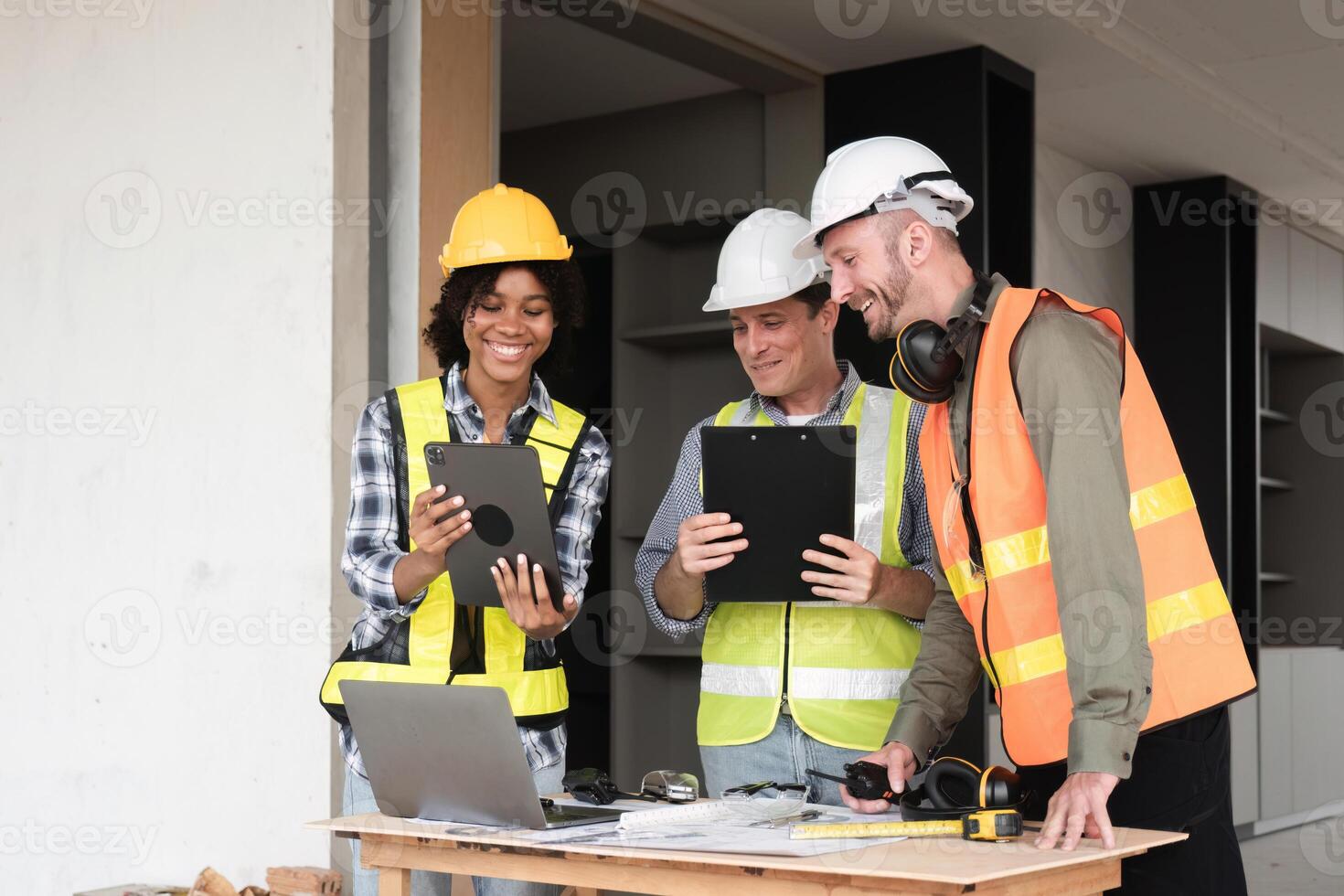 Engineering Team Collaborates on Work Plan with Digital Tablet and Laptops in Modern Construction Site photo