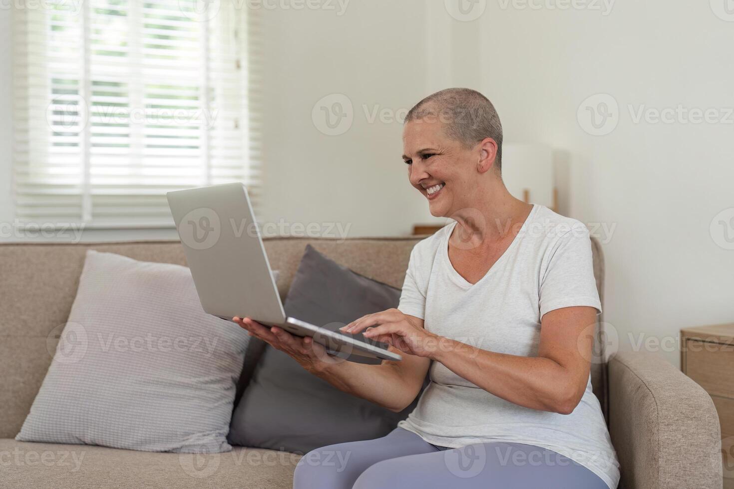 Elderly Woman Relaxing on Couch and Exploring Social Media on Laptop in Cozy Home Environment photo