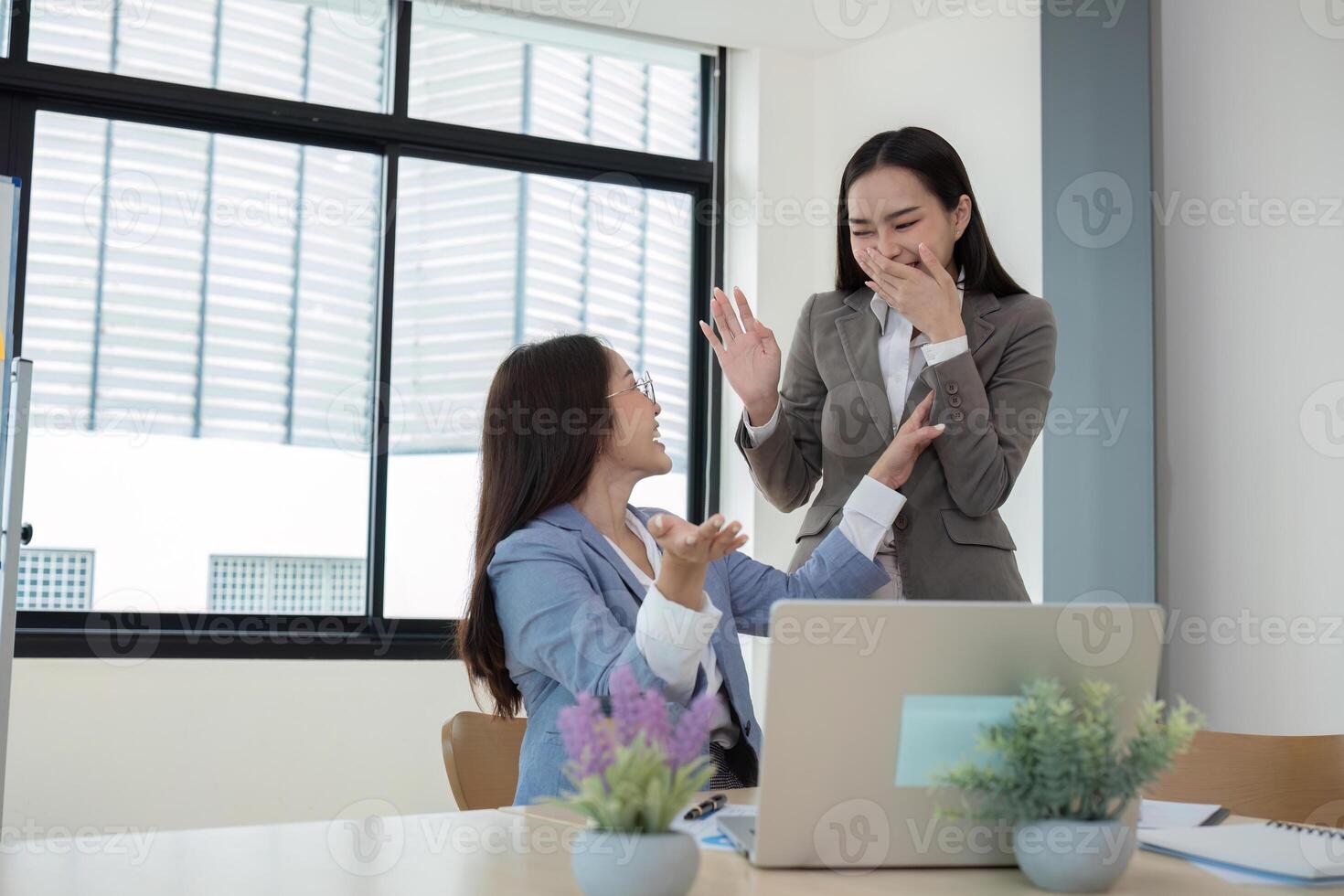 Two Young Accountant Celebrating Success in Modern Office Environment with Laptops and Documents photo