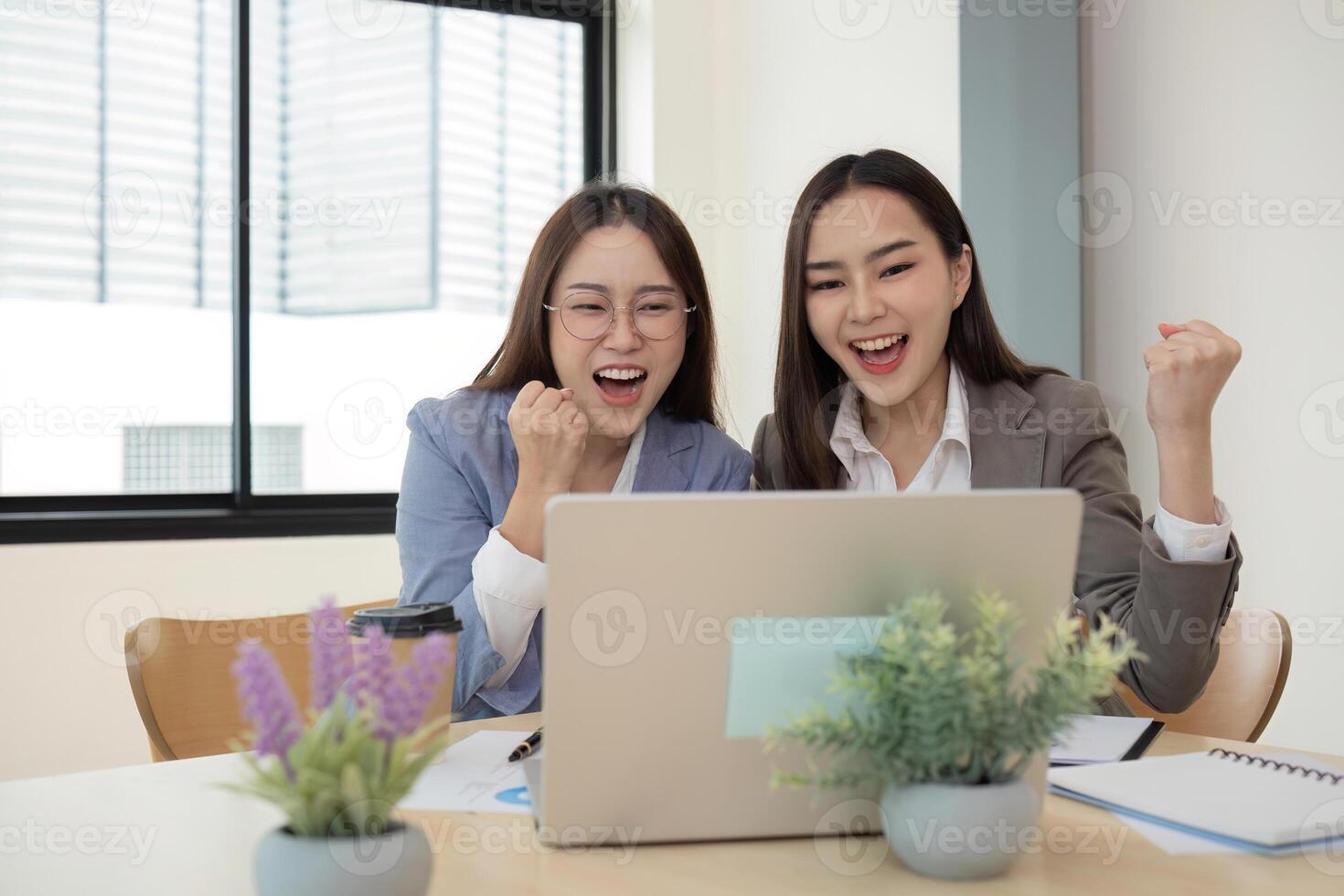 Two Female Accountant Collaborating on Financial Graphs and Data Analysis in a Modern Office Setting photo
