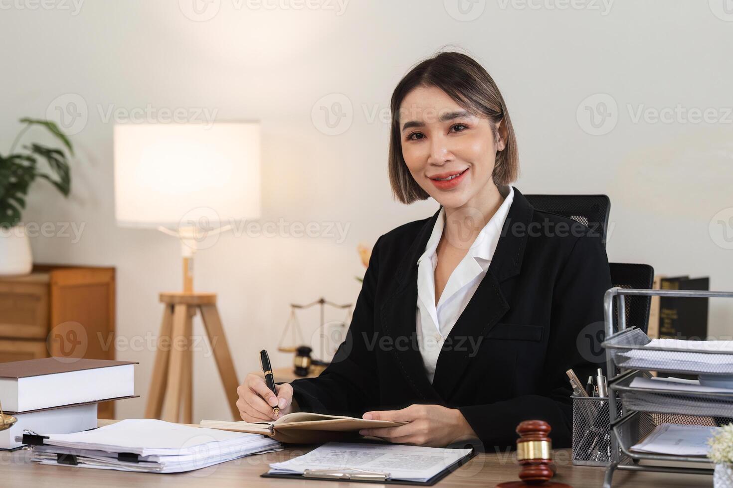 Professional Female Lawyer Reviewing Legal Documents in Modern Office Setting for Lawsuit Preparation photo