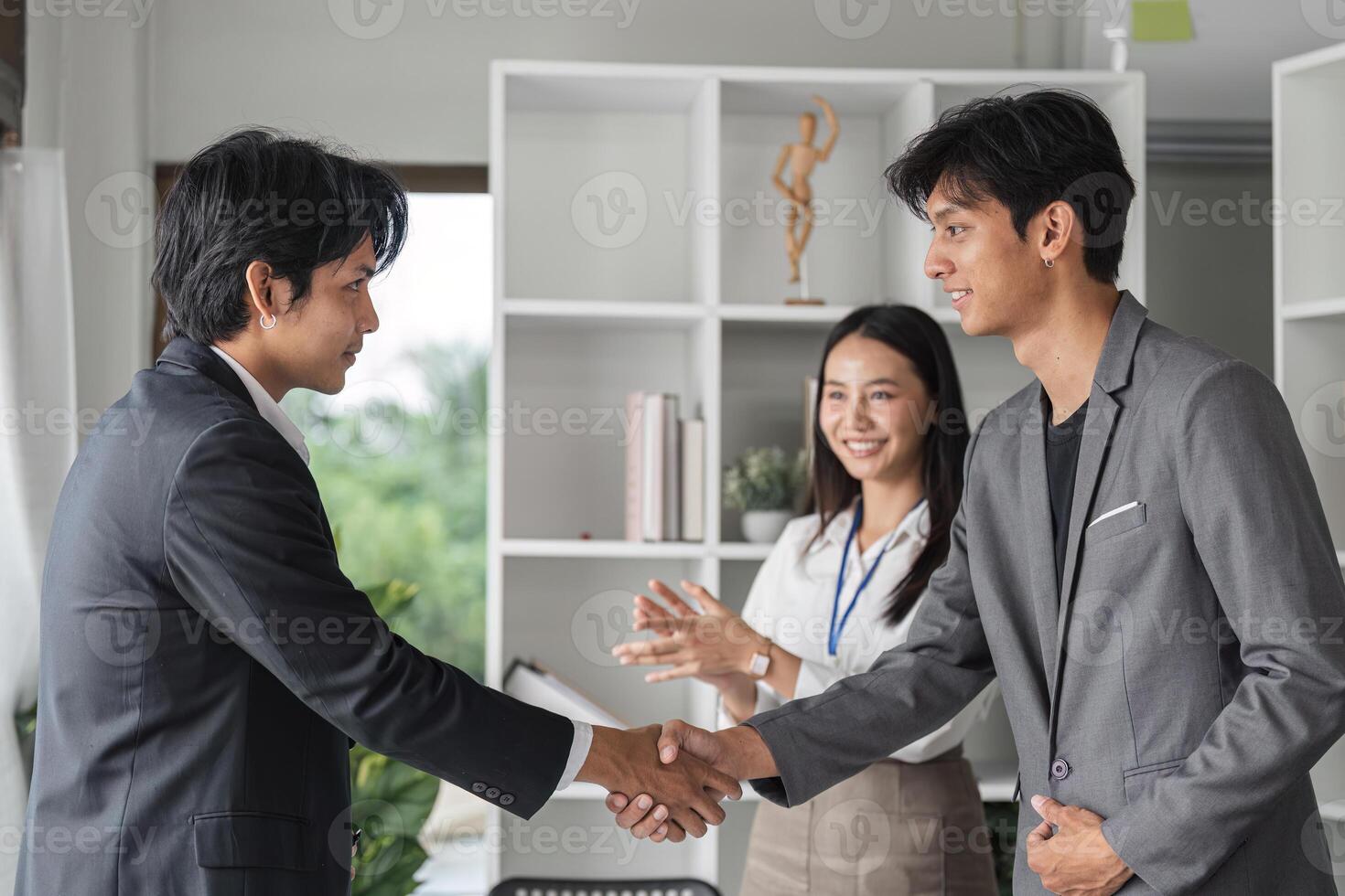 Diverse and Successful Business Team Shaking Hands in Modern Office Environment photo